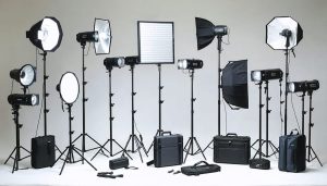 A professional studio showcasing an array of product photography lighting equipment, including LED panels, strobes, speedlights, and light modifiers like softboxes and reflectors, illustrating the transformation of any space into a quality imaging environment.