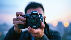A professional photographer adjusting a DSLR camera's settings with a backdrop of a blurred city skyline, symbolizing mastery of manual mode in low-light conditions.