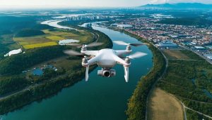 Aerial view of a drone flying over a cityscape with surrounding natural landscapes, illustrating the blend of technical drone controls and beautiful aerial photography perspectives.