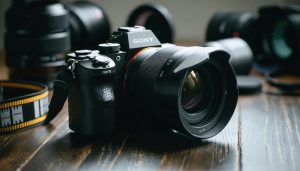 Sony A7III camera set up with a cinematic lens on a tripod, surrounded by film-related equipment like reels and filters, illustrating the transformation into a film-like camera.