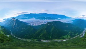 A wide-angle panoramic view showcasing a seamless transition from a majestic mountain landscape to a vibrant cityscape, illustrating the immersive quality and detail of panoramic photography.