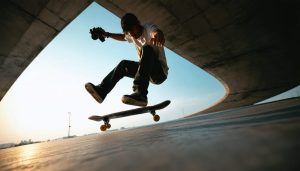 A photographer capturing a skateboarder performing a high-flying trick from a low-angle perspective, showcasing the impact of dynamic camera angles in action photography.