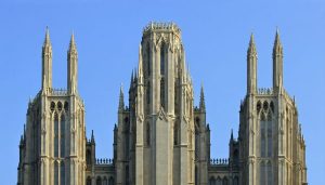 Vertical panorama of a Gothic cathedral's spires reaching into the sky, showcasing intricate architectural details from base to peak.