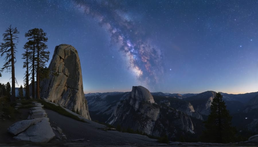 Wide night-sky view from Glacier Point showing Half Dome under the Milky Way core, with a granite outcrop and a lone Jeffrey pine in the foreground and faint moonlight illuminating the rock faces.